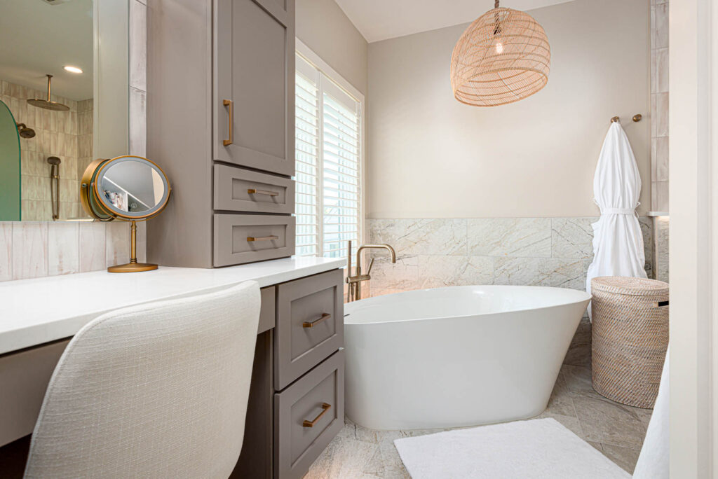 above floor soaking tub with gray cabinetry